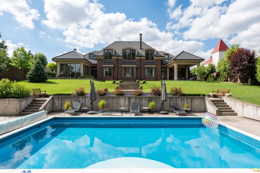 Elegant mansion with a sparkling pool and well-maintained garden, ideal for luxury living.